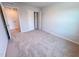 A carpeted bedroom with walk-in closet and an entrance to another room at 457 Duncan Creek Rd # 141, Lillington, NC 27546