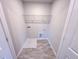 A compact laundry room featuring utility connections and an overhead wire shelf at 457 Duncan Creek Rd # 141, Lillington, NC 27546