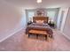 Carpeted main bedroom with a padded headboard, bench, and dual windows at 457 Duncan Creek Rd # 141, Lillington, NC 27546