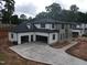 New home with a three-car garage and modern curb appeal, plus a freshly paved driveway at 865 Wimbleton Dr, Raleigh, NC 27609