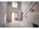 Spacious two-story foyer featuring wooden front doors, staircase, and ample natural light from a window at 865 Wimbleton Dr, Raleigh, NC 27609