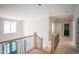 Second-floor hallway with a window, wooden railing, and access to various rooms at 865 Wimbleton Dr, Raleigh, NC 27609