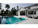 A modern white home has an inviting pool with lounge chairs and stylish patio furniture at 865 Wimbleton Dr, Raleigh, NC 27609