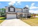 Charming two-story home with a long driveway, attached garage, and manicured front lawn at 541 Henham Way, Zebulon, NC 27597