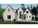 Stunning two-story home with white brick, gray accents, large windows, and a well-manicured lawn at 708 Catawba St, Raleigh, NC 27609