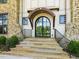 Elegant arched front door with stone steps, decorative iron railing, and a stone and siding exterior at 1641 Legacy Ridge Ln, Wake Forest, NC 27587