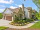 Attached two-car garage with stone and siding accents surrounded by manicured landscaping at 1641 Legacy Ridge Ln, Wake Forest, NC 27587