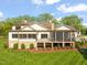 Rear exterior view showcasing a screened in porch, balcony, and stone foundation at 1641 Legacy Ridge Ln, Wake Forest, NC 27587