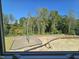 View of treelined backyard with small playground at 1328 Bessie Ct, Wake Forest, NC 27587