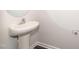 Compact powder room featuring a modern pedestal sink, chrome faucet, and a round mirror, ideal for guests at 567 Marthas Vw Way, Wake Forest, NC 27587