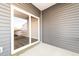 Covered patio area with grey siding and large sliding glass door, perfect for outdoor relaxation at 569 Marthas Vw Way, Wake Forest, NC 27587