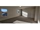 Sunlit bedroom featuring neutral carpet and two windows, with a glimpse of neighborhood rooftops at 115 Shooting Star Trl, Youngsville, NC 27596