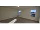 Bright bedroom with carpet and two windows, offering views of neighborhood rooftops at 115 Shooting Star Trl, Youngsville, NC 27596