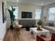 Bright living room with modern furnishings, large windows, and a decorative plant, perfect for relaxation at 115 Shooting Star Trl, Youngsville, NC 27596