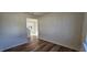 Well-lit room with wood-look flooring and a view into the next room at 115 Shooting Star Trl, Youngsville, NC 27596