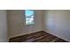 Well-lit room with wood-look flooring and a window offering a view of the outdoors at 115 Shooting Star Trl, Youngsville, NC 27596