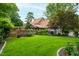 Lush backyard featuring manicured lawn, mature trees, and charming brick accents, perfect for outdoor enjoyment at 1800 Bay Meadow Ct, Raleigh, NC 27615