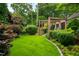Professionally landscaped backyard featuring a verdant lawn, mature trees, and manicured shrubs for added privacy at 1800 Bay Meadow Ct, Raleigh, NC 27615
