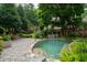 Lush backyard with mature trees, manicured landscaping, and a sparkling pool creating a private oasis at 1800 Bay Meadow Ct, Raleigh, NC 27615