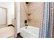 Bathroom with a white tub and shower with earth tone tile and dark bronze fixtures at 1800 Bay Meadow Ct, Raleigh, NC 27615