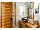 Powder room complete with wooden vanity, vessel sink, modern lighting and wooden door at 1800 Bay Meadow Ct, Raleigh, NC 27615