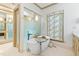 An elegant bathroom showcases a soaking tub, a custom window shade, and a connecting glass-enclosed shower at 1800 Bay Meadow Ct, Raleigh, NC 27615