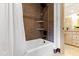 Bathroom with white tub and shower with brown tile and dark bronze fixtures and white shower curtain at 1800 Bay Meadow Ct, Raleigh, NC 27615