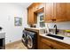This is a well-lit laundry room complete with modern washer/dryer and custom cabinets at 1800 Bay Meadow Ct, Raleigh, NC 27615