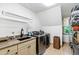 Functional laundry room with modern washer and dryer units, granite countertop and a sink at 1800 Bay Meadow Ct, Raleigh, NC 27615