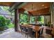 Covered outdoor dining area with seating for eight overlooks a lush backyard, perfect for entertaining at 1800 Bay Meadow Ct, Raleigh, NC 27615
