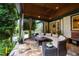 Covered patio with a ceiling fan, outdoor seating, and lush greenery offers a serene outdoor escape at 1800 Bay Meadow Ct, Raleigh, NC 27615