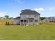 Spacious backyard featuring a gray two-story home with a screened porch and a fenced perimeter at 25 Cotton Fields Ln # 29, Fuquay Varina, NC 27526