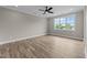 Light-filled bedroom showcases wood-look flooring, neutral walls, white trim, and a large window with neighborhood view at 25 Cotton Fields Ln # 29, Fuquay Varina, NC 27526