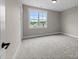 Bright bedroom showcasing plush carpet, neutral walls, white trim, and a large window with neighborhood view at 25 Cotton Fields Ln # 29, Fuquay Varina, NC 27526
