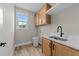 Efficient laundry room includes wood-look flooring, sink, cabinets, countertop, and a bright window at 25 Cotton Fields Ln # 29, Fuquay Varina, NC 27526