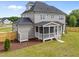 Rear exterior view of a gray two-story home featuring a screened porch and well-maintained lawn at 25 Cotton Fields Ln # 29, Fuquay Varina, NC 27526