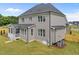 Back of a two-story gray home with screened porch, showcasing a spacious yard and meticulous landscaping at 25 Cotton Fields Ln # 29, Fuquay Varina, NC 27526