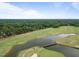 Aerial view of a golf course community with a pond and houses at 90 Brandon Dr, Lillington, NC 27546