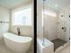 Modern bathroom featuring a soaking tub next to a frameless shower with marble surround at 205 Wash Hollow Dr, Wendell, NC 27591