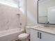 Well-lit bathroom featuring white cabinets, granite counters, a tub and shower with marble surround at 205 Wash Hollow Dr, Wendell, NC 27591