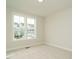 Bright bedroom featuring neutral carpet and a large window that offers views of the surrounding neighborhood at 205 Wash Hollow Dr, Wendell, NC 27591