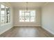 Bright dining room with hardwood floors, decorative lighting fixture, and large windows offering natural light at 205 Wash Hollow Dr, Wendell, NC 27591