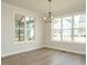 Bright dining room with hardwood floors, decorative lighting fixture, and large windows offering natural light at 205 Wash Hollow Dr, Wendell, NC 27591