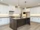Beautiful kitchen features white cabinets, stainless steel appliances, an island, and hardwood floors at 205 Wash Hollow Dr, Wendell, NC 27591