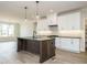 Well-lit kitchen featuring white cabinets, granite countertops, and a large dark wood center island with pendant lighting at 205 Wash Hollow Dr, Wendell, NC 27591