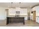 Modern kitchen with white cabinets, granite countertops, and a large center island with a sink and stylish pendant lighting at 205 Wash Hollow Dr, Wendell, NC 27591