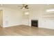 Open living room boasts hardwood floors, a ceiling fan, a fireplace with built-in shelves, and lots of natural light at 205 Wash Hollow Dr, Wendell, NC 27591