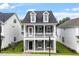 Charming two-story home with a welcoming front porch, dormer windows and manicured lawn at 9301 Kitchin Farms Way # 433, Wake Forest, NC 27587
