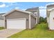 Spacious garage with white door and gray exterior, surrounded by green lawn at 9301 Kitchin Farms Way # 433, Wake Forest, NC 27587