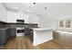 Bright kitchen featuring a granite island, stainless appliances, gray cabinets, and hardwood floors at 320 Church St, Morrisville, NC 27560